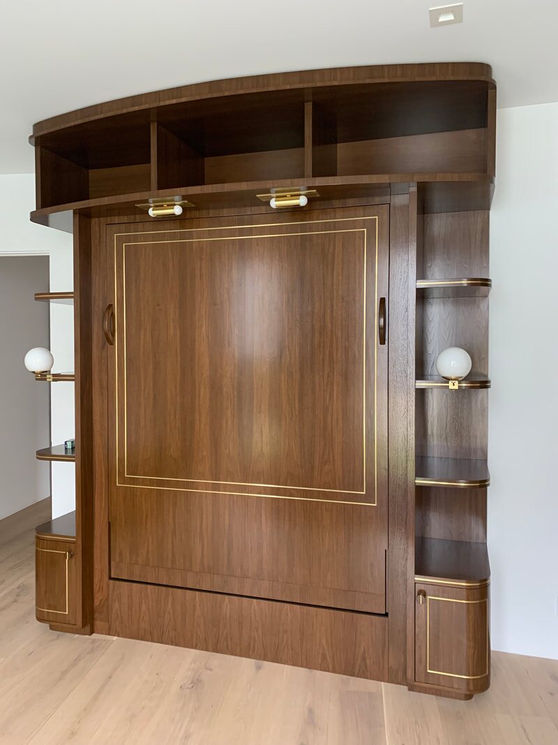 Walnut wall bed with brass inlay and shelving
