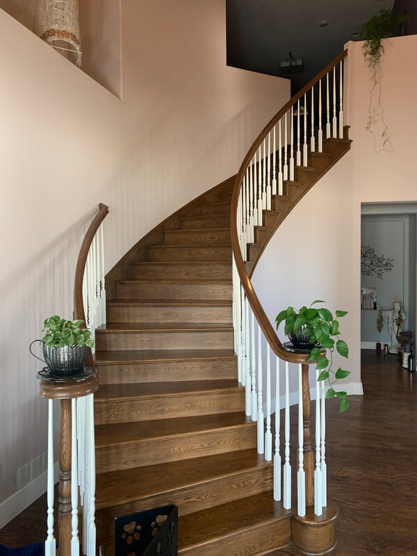 Curved wood staircase with painted spindles