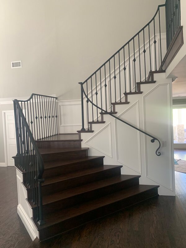 Dark wood staircase with custom iron railing